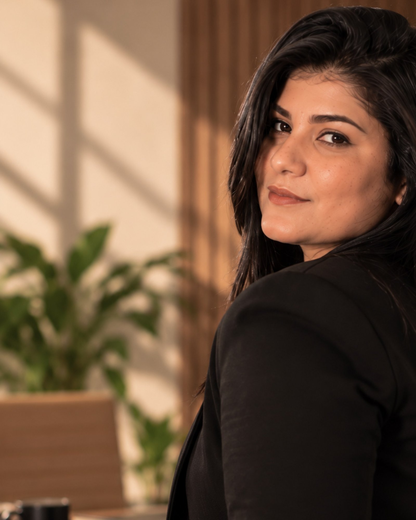 Larissa Almeida olhando por cima do ombro, em seu escritório